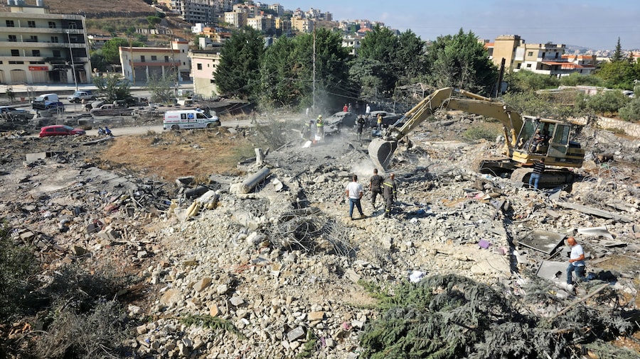 Macchinari pesanti all'opera sul luogo di un attacco israeliano a Kfar Rumman, in Libano. (REUTERS)