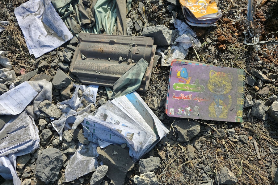 Libri danneggiati giacciono tra le macerie nel luogo in cui si è verificato un attacco israeliano, a Kfar Rumman. (REUTERS)