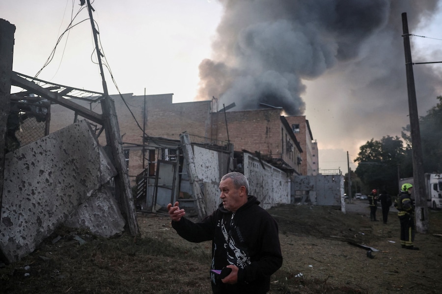 Un residente reagisce sul luogo di un attacco sferrato da missili e droni russi, mentre il fumo sale da un edificio non residenziale colpito durante l'attacco, nel contesto dell'offensiva russa contro l'Ucraina, a Kiev. (REUTERS)