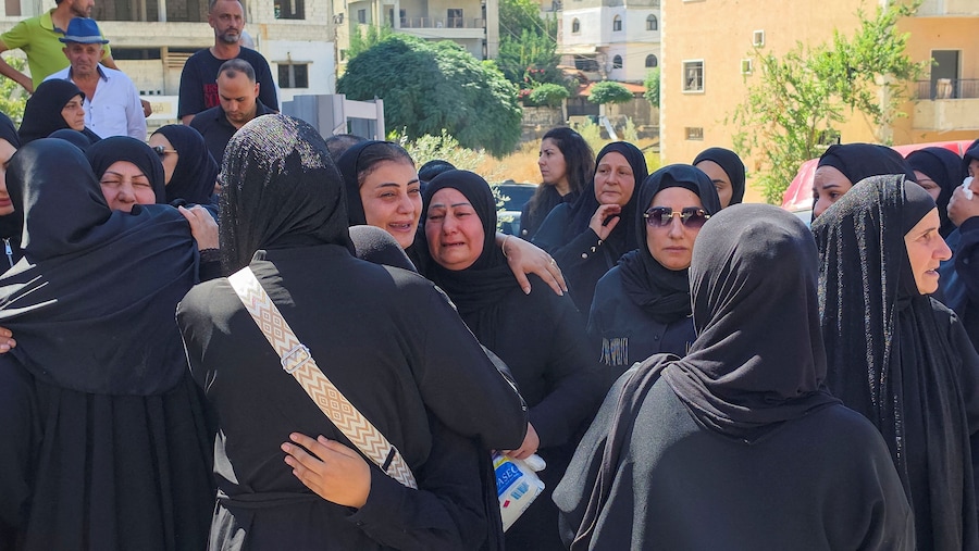 I partecipanti al funerale reagiscono mentre assistono alla cerimonia funebre delle dodici persone uccise negli attacchi israeliani a Kfar Rumman, nel Libano meridionale. (REUTERS)