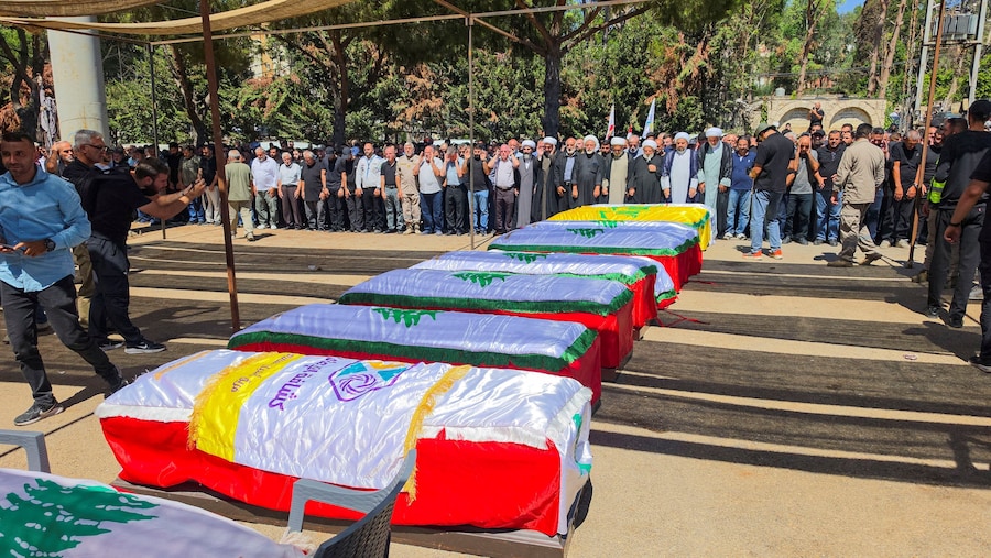 La gente partecipa al funerale delle dodici persone uccise nei raid israeliani su Kfar Rumman, nel Libano meridionale. (REUTERS)