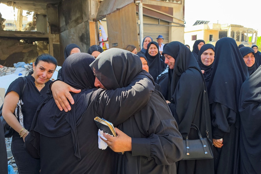 I partecipanti al funerale reagiscono mentre assistono alla cerimonia funebre delle dodici persone uccise nei raid israeliani su Kfar Rumman, nel Libano meridionale. (REUTERS)