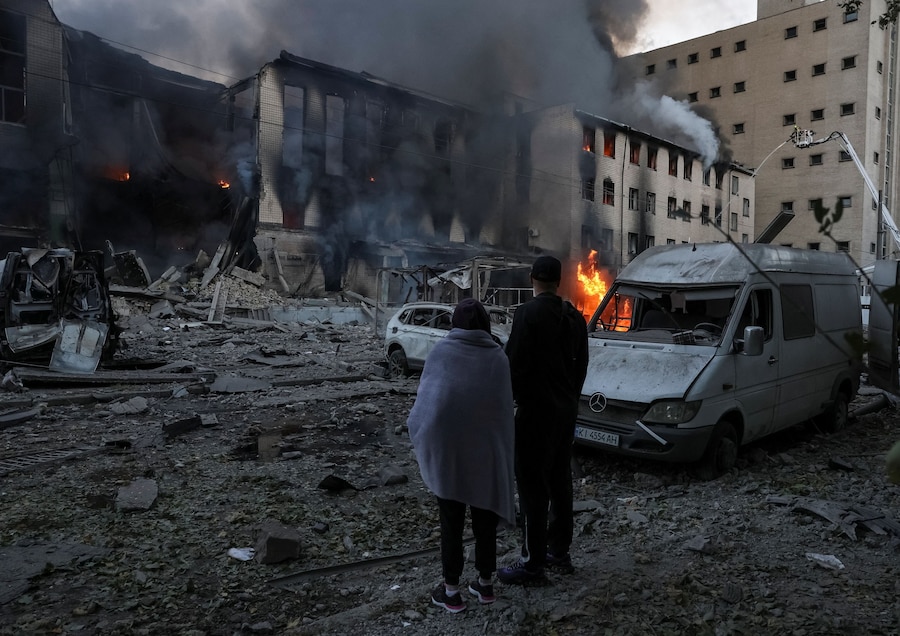 Alcuni residenti si trovano sul luogo di un attacco missilistico russo, nel contesto dell'offensiva russa contro l'Ucraina, a Kiev. (REUTERS)