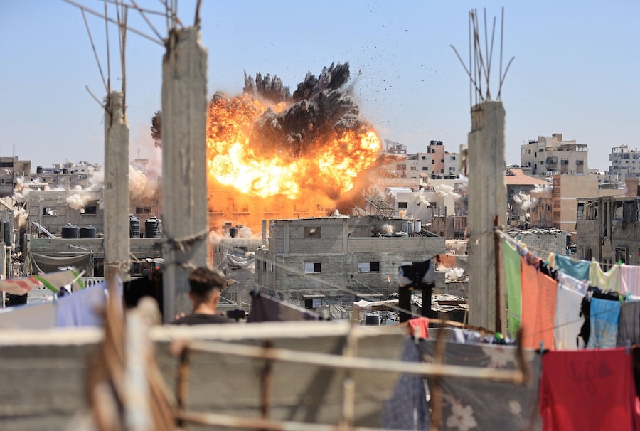 Fumo e fiamme si levano da un’abitazione durante un attacco israeliano, sferrato dopo che l’esercito israeliano aveva intimato ai residenti di evacuare la zona, nel campo profughi di Al Shati a Gaza City (REUTERS)