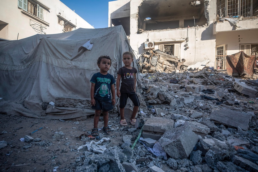 Bambini palestinesi sfollati interni in piedi vicino alla tenda della loro famiglia dopo un attacco aereo israeliano nei pressi dell’ospedale Al-Shifa nella città di Gaza (EPA)
