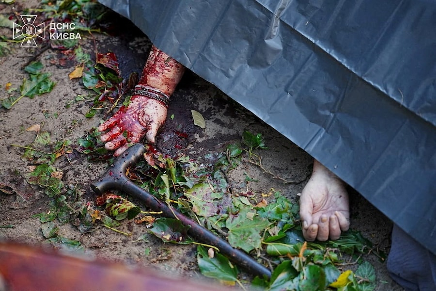 Il corpo di un residente ucciso, coperto da un sacchetto di plastica, giace a terra sul luogo di un condominio colpito da un attacco con droni russi a Kiev (via REUTERS)