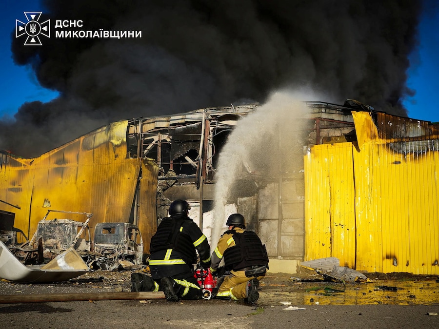 I vigili del fuoco intervengono sul luogo di un magazzino colpito durante gli attacchi aerei e con droni russ a Mykolaiv, Ucraina (via REUTERS)