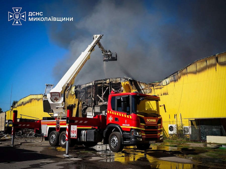 I vigili del fuoco intervengono sul luogo di un magazzino colpito durante gli attacchi aerei e con droni russi a Mykolaiv, Ucraina (via REUTERS)