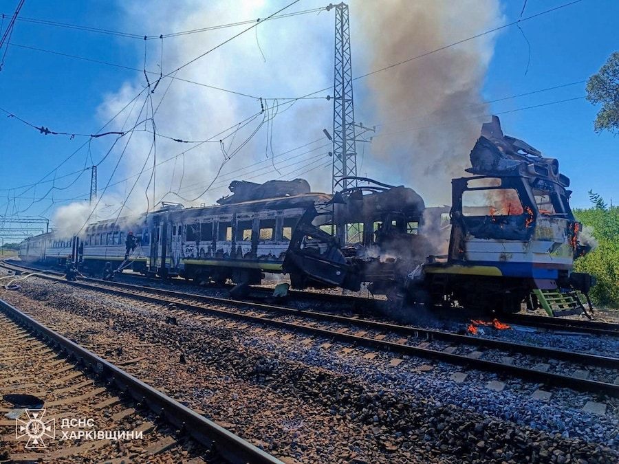 I vigili del fuoco intervengono sul luogo in cui un treno passeggeri è stato colpito da un drone russo nella regione di Kharkiv, Ucraina (via REUTERS)