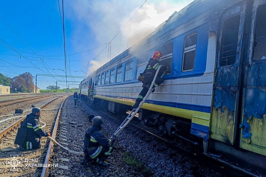 I vigili del fuoco intervengono sul luogo in cui un treno passeggeri è stato colpito durante un attacco con droni russi nella regione di Kharkiv, Ucraina (via REUTERS)