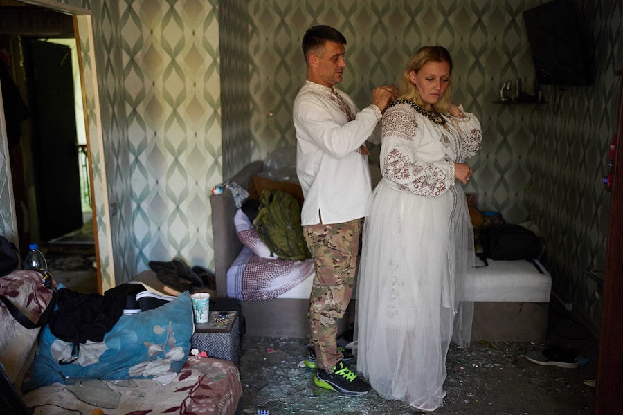 Liudmyla Ryzhak e il suo fidanzato Leonid Ryzhak si preparano per la cerimonia di nozze nel loro appartamento danneggiato, in seguito a un attacco russo con missili e droni a Kiev (APN)