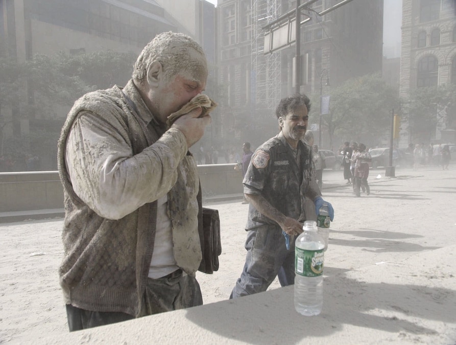 Un uomo si pulisce il viso dopo essere stato investito dalle ceneri del crollo delle torri del World Trade Center, a New York, l'11 settembre 2001. (APN)