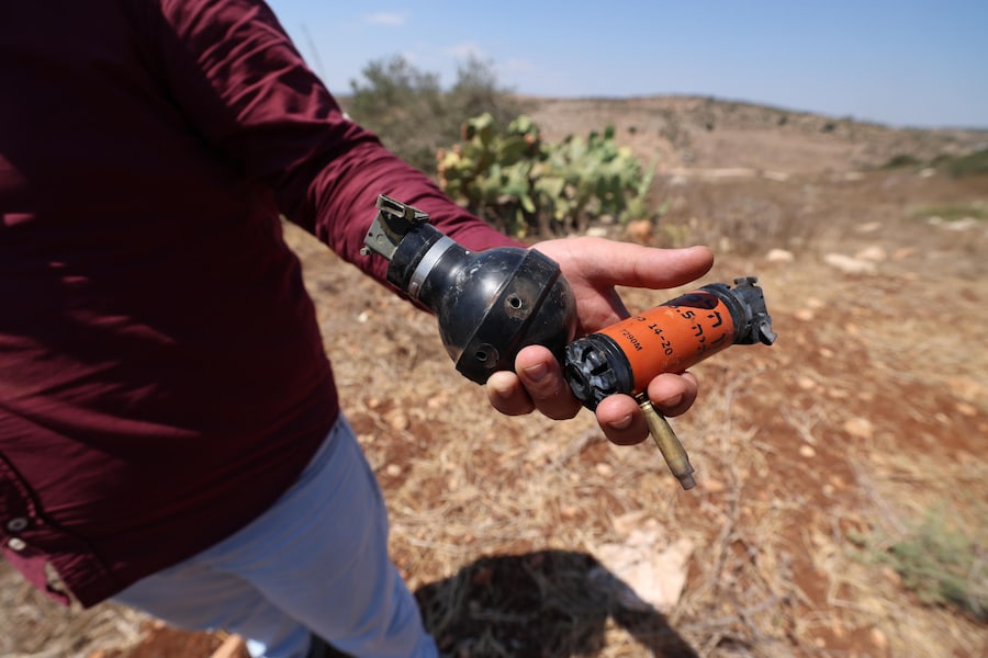 Un uomo palestinese mostra bossoli vuoti e bombolette di gas lacrimogeno dopo l’attacco sferrato dai coloni israeliani al villaggio palestinese di Fuqoua, a nord-ovest di Jenin, in Cisgiordania, il 12 settembre 2026. Secondo l’agenzia palestinese WAFA, un uomo palestinese è stato colpito e ferito durante uno scontro tra coloni israeliani e abitanti del villaggio palestinese. EPA/ALAA BADARNEH (EPA)