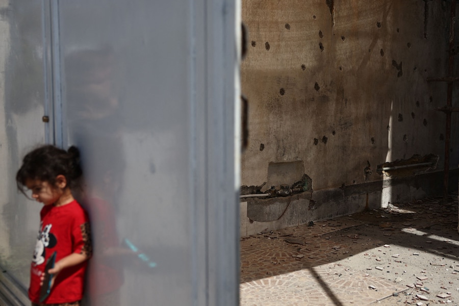 Una ragazza si trova vicino ai segni lasciati dalle schegge sul muro di un'abitazione dopo un attacco avvenuto il 28 febbraio, a Lamerd, in Iran, il 12 settembre 2026. Majid Asgaripour/WANA (West Asia News Agency) via REUTERS (via REUTERS)