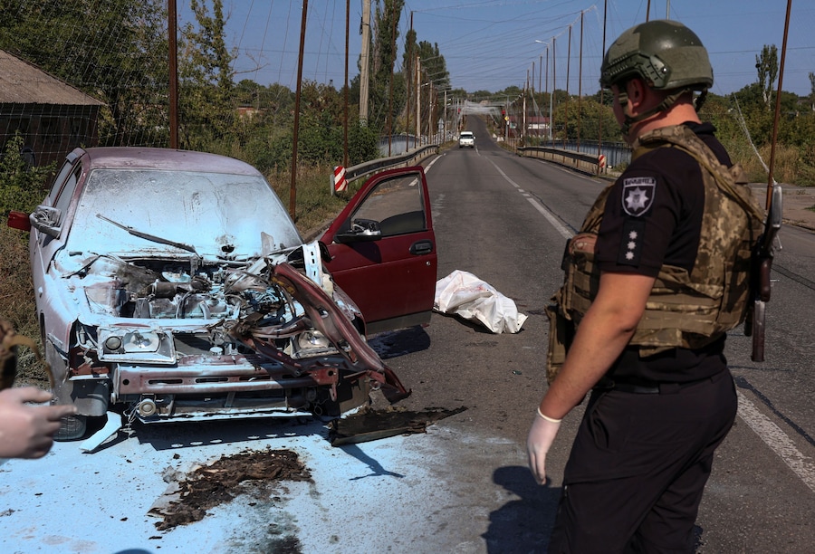 Un agente di polizia è in piedi accanto al corpo di un residente ucciso all’interno della propria auto dal colpo sferrato da un drone FPV russo nella città di Kramatorsk, in prima linea nel conflitto, nel corso dell’attacco russo all’Ucraina, nella regione di Donetsk, Ucraina, il 12 settembre 2026. REUTERS/Anatolii Stepanov (REUTERS)