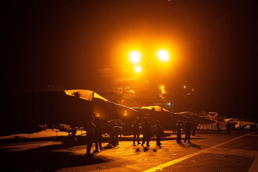 I marinai della Marina degli Stati Uniti aiutano a far decollare aerei da combattimento e altri velivoli durante operazioni notturne sul ponte di volo della USS George Washington nel Mar Arabico. (REUTERS)