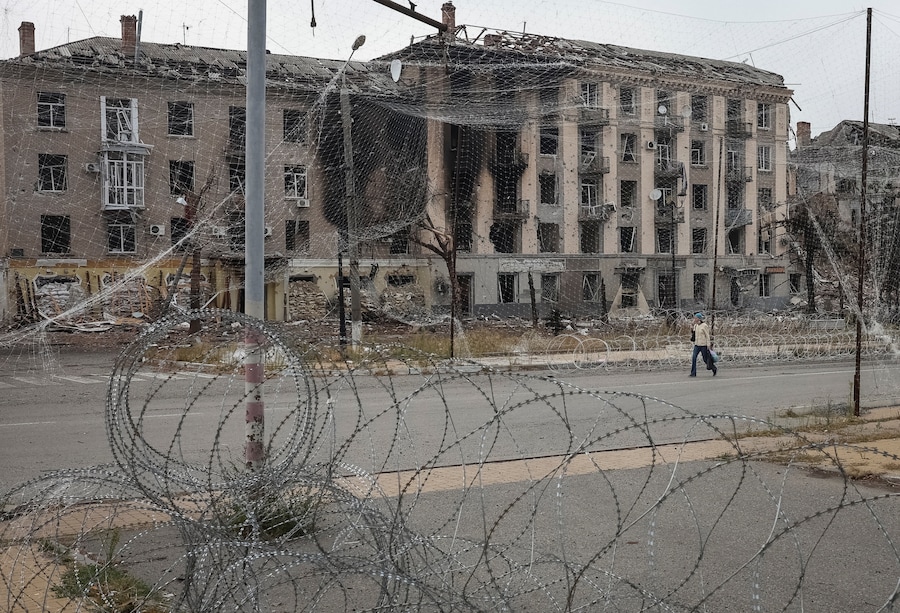Un abitante cammina lungo una strada coperta da reti anti-drone e con filo spinato installato nelle vicinanze, mentre la Russia attacca l’Ucraina, nella città di Druzhkivka, in prima linea nella regione di Donetsk. (REUTERS)