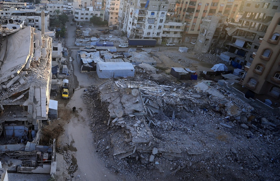 Alcuni palestinesi camminano vicino alle macerie di un edificio residenziale che era stato danneggiato in un precedente attacco israeliano durante la guerra e che è crollato mercoledì, nella città di Gaza, il 17 settembre 2026. (REUTERS)