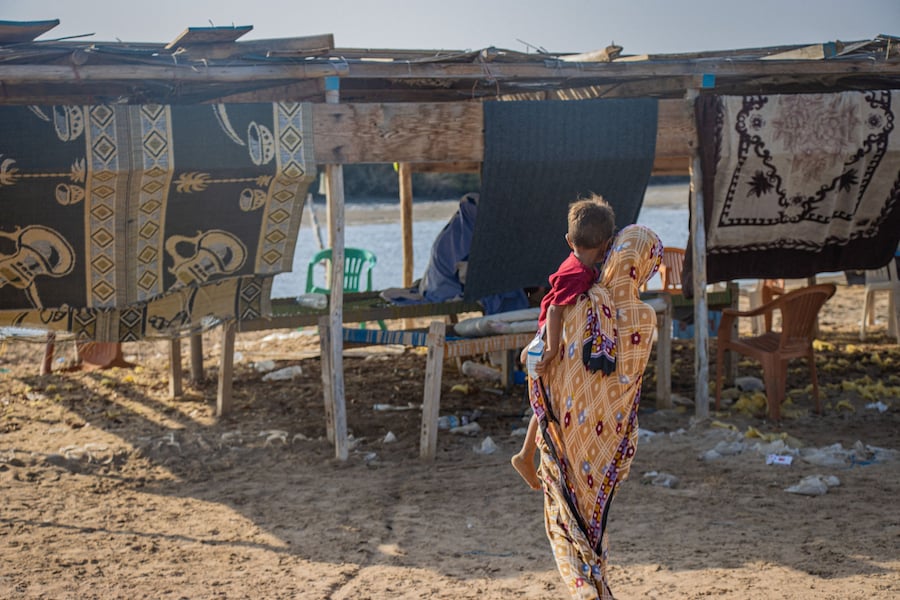 Una donna, fuggita dagli scontri tra i combattenti houthi e le forze governative yemenite sostenute dall’Arabia Saudita, porta in braccio un bambino sulle rive di Khor Angar, vicino a Obock, sulla costa settentrionale del Golfo di Tadjoura, che si affaccia sul Golfo di Aden, a Gibuti, il 16 settembre 2026. (via REUTERS)