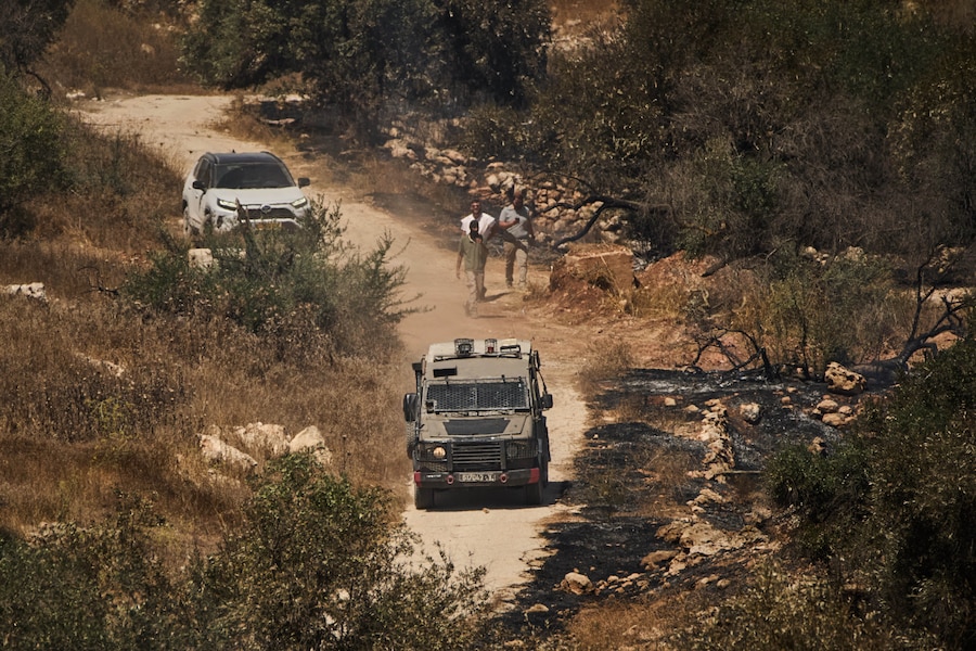 Un veicolo dell’esercito israeliano è visibile accanto a coloni israeliani mentre impediscono l’accesso ai palestinesi del posto nel villaggio di Burqa, in Cisgiordania, giovedì 17 settembre 2026, a seguito di un attacco da parte dei coloni che, secondo i residenti, hanno appiccato il fuoco nella zona. (APN)