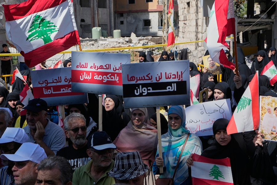 Le persone che non hanno potuto fare ritorno nei propri villaggi a causa della guerra con Israele sventolano bandiere libanesi e espongono cartelli durante una manifestazione di protesta a Nabatiyeh, nel sud del Libano, giovedì 17 settembre 2026. Il testo di un cartello al centro recita: “L’aggressione non spezzerà la nostra volontà”. (APN)