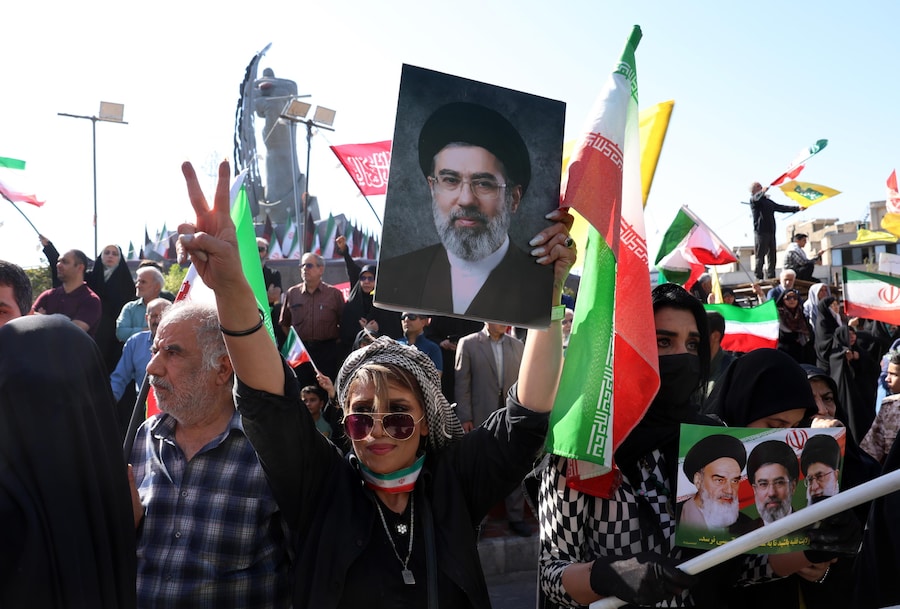 Una donna iraniana tiene in mano una foto del leader supremo iraniano, l’ayatollah Mojtaba Khamenei, mentre osserva i membri delle forze armate iraniane appartenenti al gruppo paramilitare Basij, parte del Corpo delle Guardie Rivoluzionarie Islamiche (IRGC), partecipare a una manifestazione militare, nota come gruppo Jan-Fada («Sacrificati per l’Iran»), a Teheran, in Iran. (EPA)