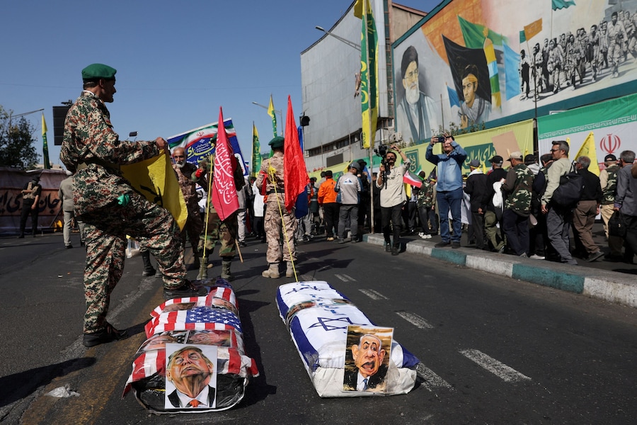 Bare con le immagini del presidente degli Stati Uniti Donald Trump e del primo ministro israeliano Benjamin Netanyahu durante una parata militare a Teheran, in Iran. (via REUTERS)