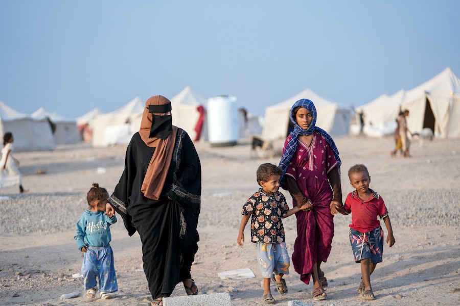 Donne e bambini, fuggiti dai combattimenti tra gli Houthi e le forze governative nelle zone costiere del Mar Rosso, camminano in un campo per sfollati interni vicino ad Aden, nello Yemen. (REUTERS)