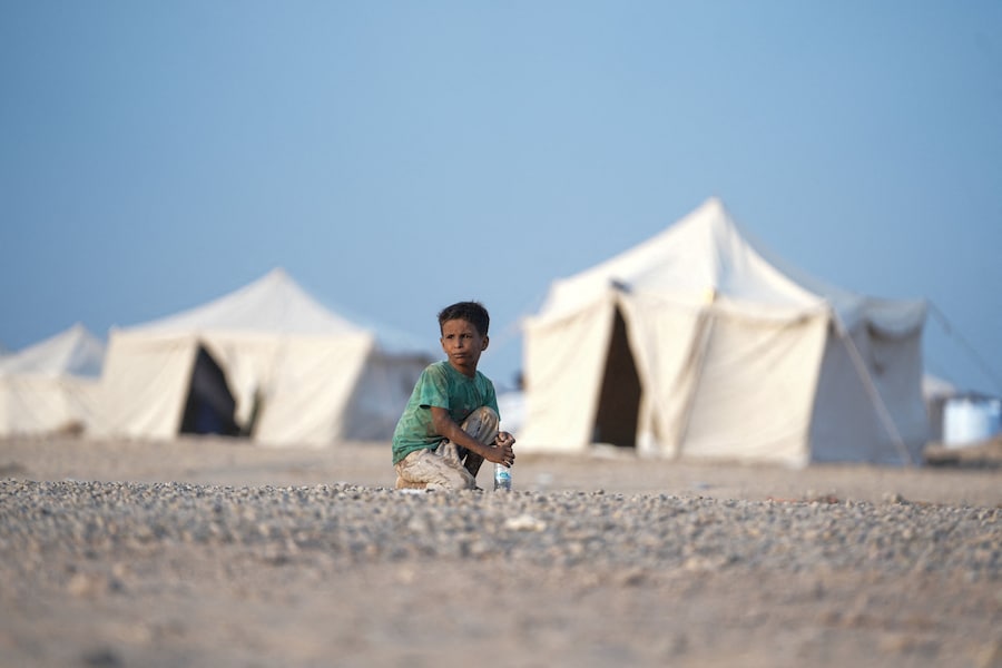 Un ragazzo, fuggito dai combattimenti tra gli Houthi e le forze governative nelle zone costiere del Mar Rosso, è seduto in un campo per sfollati interni vicino ad Aden, nello Yemen. (REUTERS)