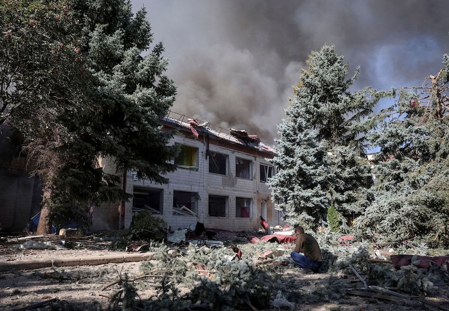 Una persona è seduta sul sito di un edificio, distrutto da un attacco aereo russo, che fungeva da centro di transito per le persone evacuate da una zona di prima linea, nel contesto dell’attacco russo all’Ucraina, nella città di Kramatorsk, in Ucraina. (REUTERS)