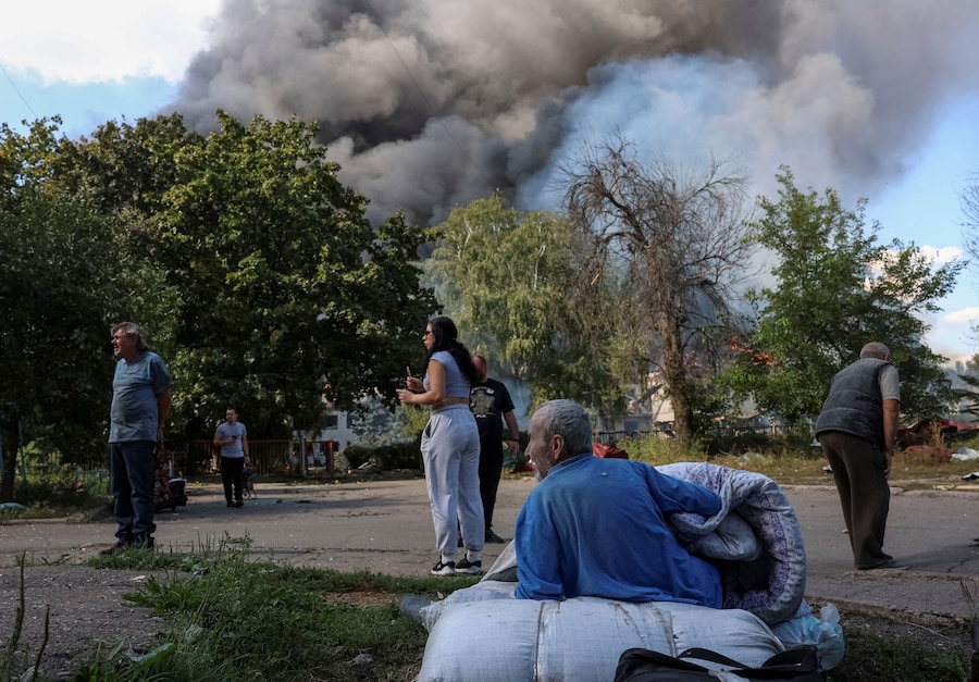 I residenti si radunano sul luogo di un edificio, distrutto da un attacco aereo russo, che fungeva da centro di transito per le persone evacuate da una zona di prima linea, nel contesto dell’attacco russo all’Ucraina, nella città di Kramatorsk, in Ucraina. (REUTERS)