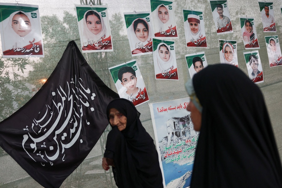 Donne davanti alle immagini che ritraggono gli studenti della scuola di Minab uccisi in un attacco, a Minab, in Iran. (Majid Asgaripour/WANA (West Asia News Agency) via REUTERS)