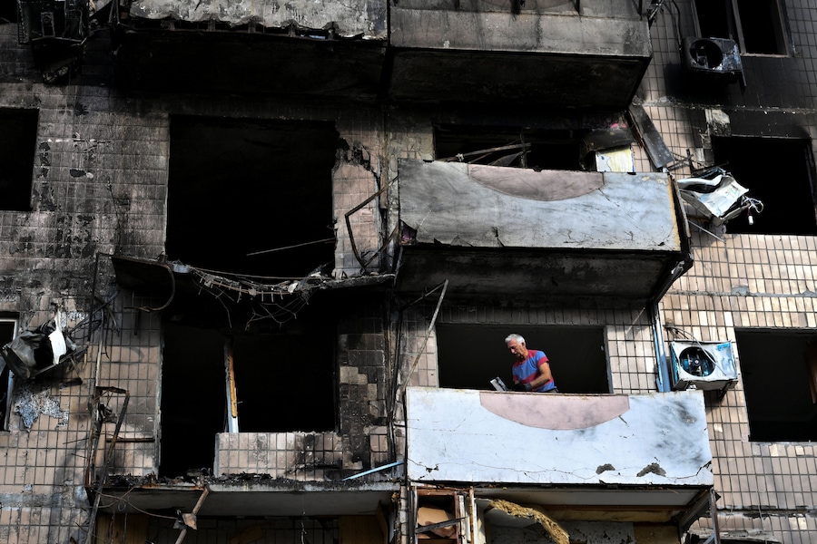Un residente rimuove i detriti dal balcone del suo condominio, danneggiato da un attacco notturno sferrato da un drone russo, nel contesto dell’offensiva russa contro l’Ucraina, a Zaporizhzhia. (REUTERS)