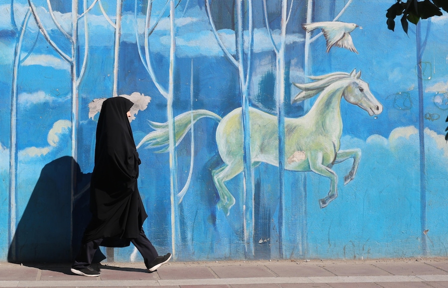 Una donna iraniana velata cammina accanto a un murales raffigurante cavalli bianchi in una strada di Teheran, in Iran, il 23 settembre 2026. Mentre il conflitto tra Iran e Stati Uniti continua, il presidente degli Stati Uniti Donald Trump ha affermato nel suo discorso all’Assemblea Generale delle Nazioni Unite di dover decidere se «annientare» l’Iran o raggiungere un accordo con il Paese. Trump ha poi dichiarato che funzionari statunitensi e iraniani si sono incontrati a New York a margine dell’Assemblea Generale delle Nazioni Unite. (EPA/Abedin Taherkenareh)