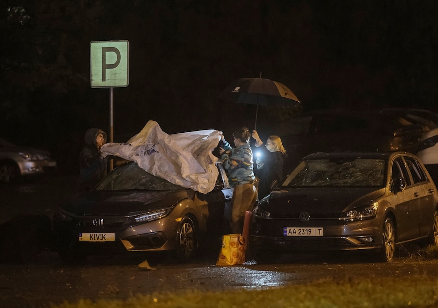 Alcuni residenti coprono la loro auto danneggiata con teli di plastica sul luogo di un attacco missilistico russo nei pressi di un ospedale ostetrico, nel contesto dell'offensiva russa contro l'Ucraina a Kiev. (REUTERS)