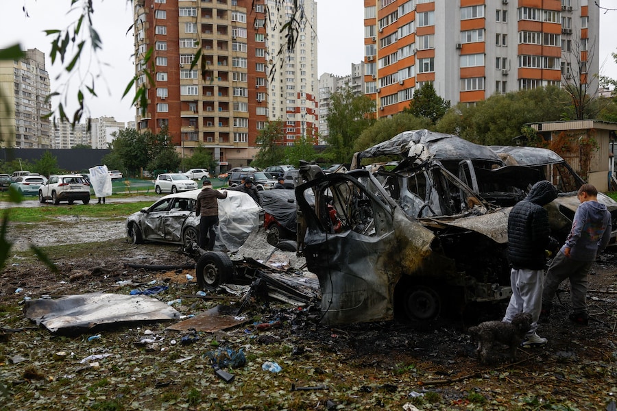 I residenti utilizzano teli di plastica per coprire le loro auto danneggiate da un attacco con droni russi in un parcheggio di una zona residenziale, nel contesto dell'offensiva russa contro l'Ucraina, a Kiev. (REUTERS)