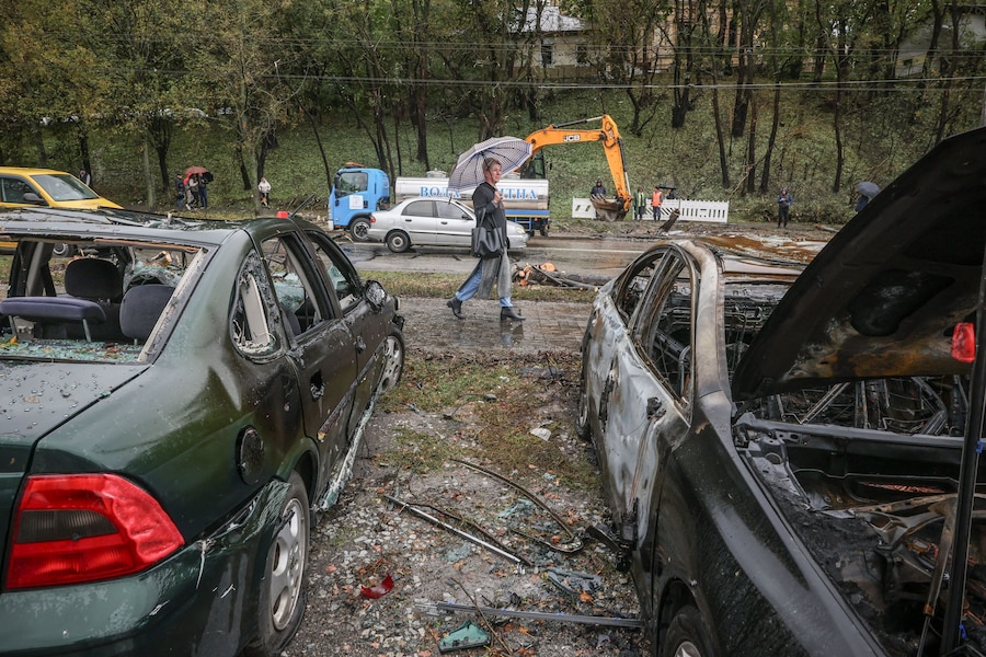 Un residente passa accanto ad alcune auto bruciate sul luogo di un attacco missilistico russo nei pressi di un centro di assistenza sanitaria di base, nel contesto dell'attacco della Russia all'Ucraina a Kiev. (REUTERS)
