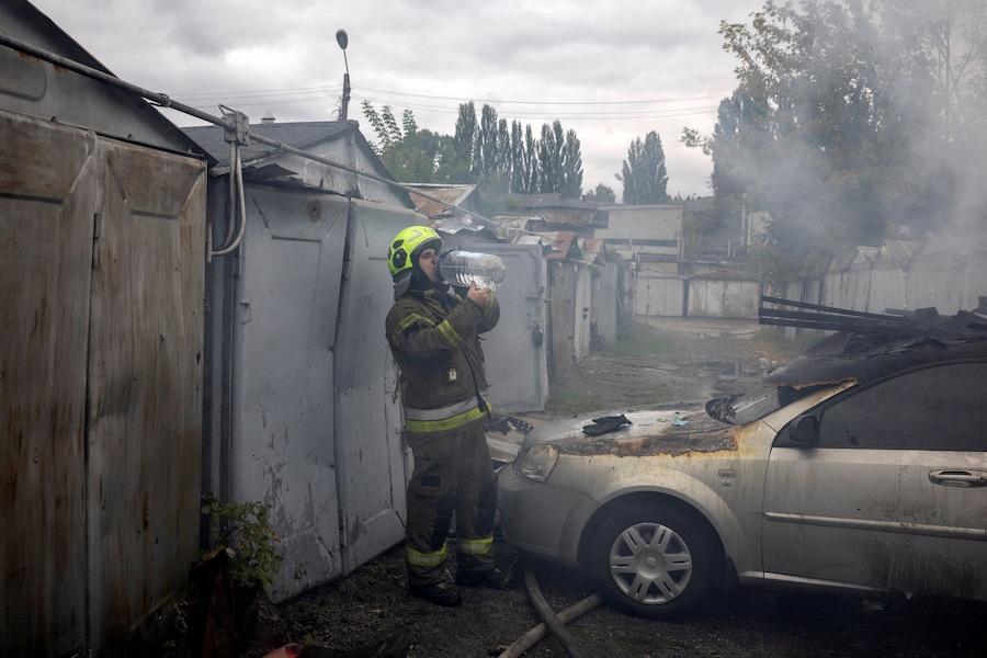 Un pompiere si reidrata mentre opera sul luogo dell'impatto dove un'esplosione ha incendiato alcuni garage durante gli attacchi con droni russi, nel contesto dell'offensiva russa contro l'Ucraina, in un quartiere residenziale di Kiev. (REUTERS)
