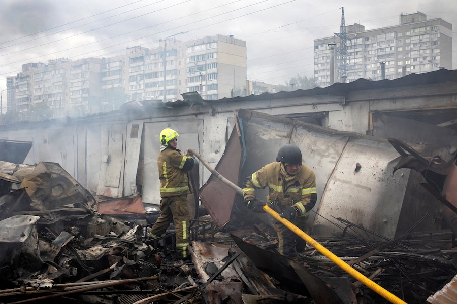 I vigili del fuoco intervengono sul luogo dell’impatto dove un’esplosione ha incendiato alcuni garage durante gli attacchi con droni russi, nel contesto dell’offensiva russa contro l’Ucraina, in un quartiere residenziale di Kiev. (REUTERS)