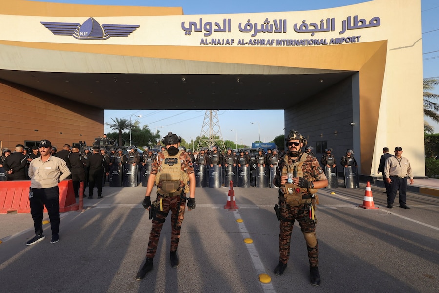 Le forze di sicurezza montano la guardia all'esterno dell'aeroporto internazionale di Najaf durante una manifestazione contro le restrizioni statunitensi che colpiscono le attività aeronautiche iraniane e il loro impatto sui voli tra l'Iran e l'Iraq, a Najaf, in Iraq. (REUTERS)