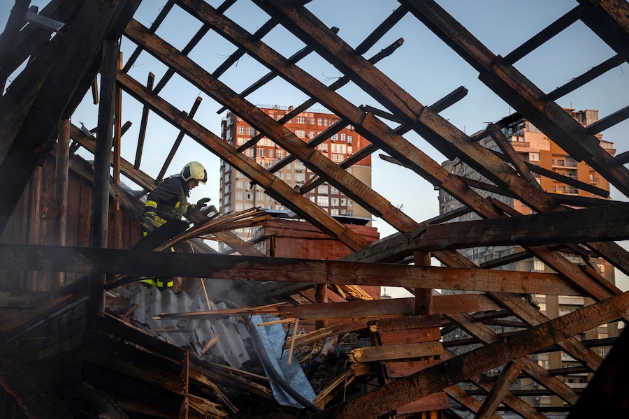 Un vigile del fuoco interviene nella soffitta di un edificio residenziale che ha preso fuoco dopo essere stato colpito da un drone russo a propulsione a reazione, nel contesto dell'attacco della Russia all'Ucraina, a Kiev. (REUTERS)