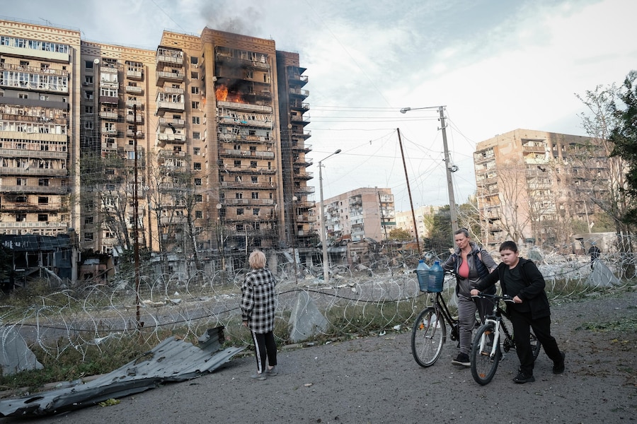 Alcune persone si trovano davanti a un edificio a più piani avvolto dalle fiamme in seguito a un attacco russo a Kramatorsk, nella regione di Donetsk, nell’Ucraina orientale. (EPA)