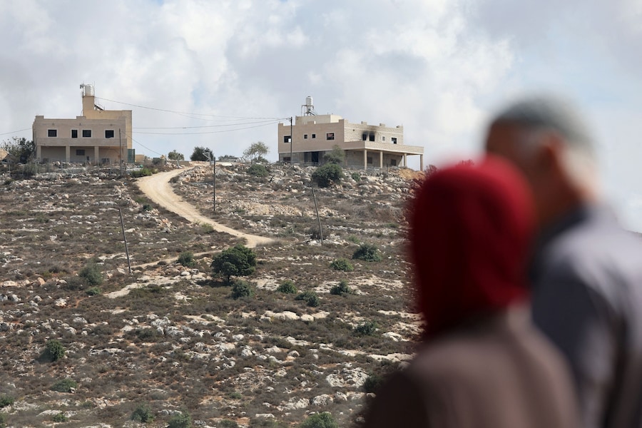 I palestinesi Mahmod Tubasi, 60 anni, e sua moglie Aedah, 51 anni, si trovano in un punto da cui si vede la loro casa, danneggiata in quello che definiscono un attacco da parte di coloni israeliani, a Jalud, nella Cisgiordania occupata da Israele, il 29 settembre 2026. REUTERS/Ammar Awad (REUTERS)