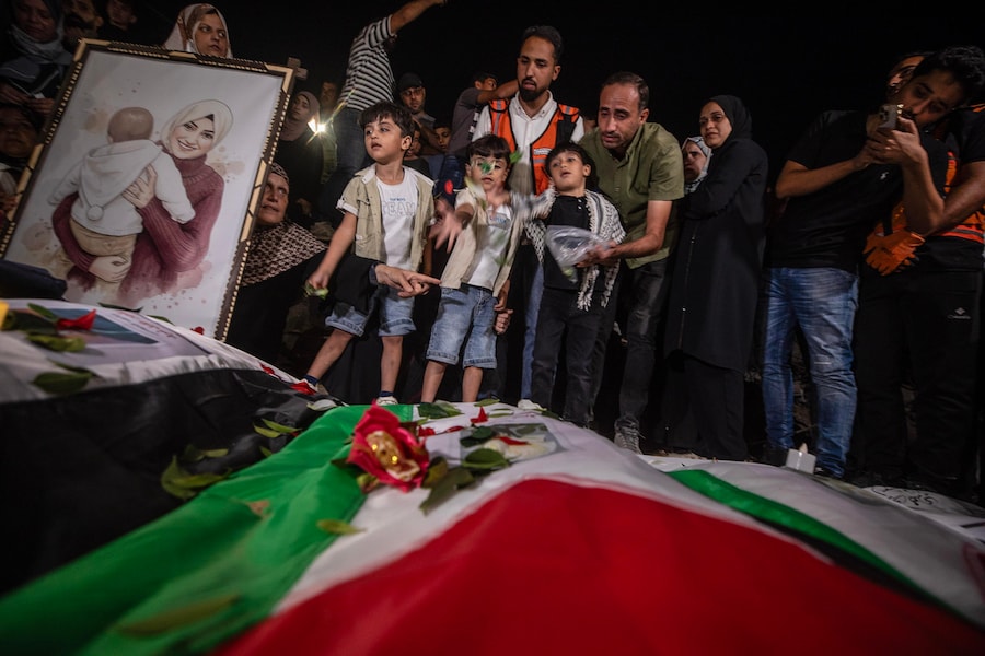 I partecipanti al funerale accendono candele durante una cerimonia funebre collettiva e una veglia in memoria di 105 palestinesi, vicino alle macerie dell’edificio Al Tajj nella città di Gaza, nella Striscia di Gaza, il 30 settembre 2026. La Protezione Civile di Gaza ha recuperato i resti da sotto le macerie del complesso residenziale Al Tajj, distrutto durante i raid aerei israeliani nell’ottobre 2023. Le vittime, tra cui donne e bambini, sono rimaste intrappolate sotto le macerie per quasi tre anni prima di essere recuperate e sepolte. EPA/MOHAMMED SABER (EPA)
