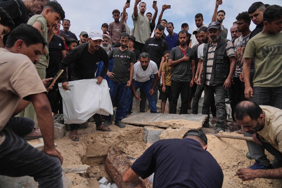 I partecipanti al funerale depongono nelle tombe i resti dei palestinesi uccisi negli attacchi israeliani durante la guerra con Hamas, dopo che erano stati recuperati dalle macerie, durante la cerimonia funebre a Nuseirat, nella Striscia di Gaza, martedì 29 settembre 2026. (AP Photo/Jehad Alshrafi) (APN)