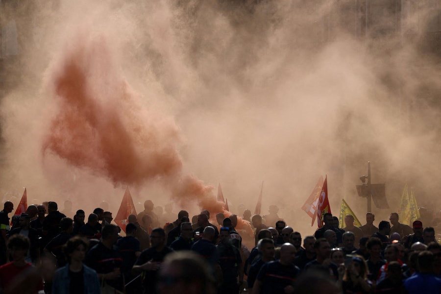 I manifestanti sfilano tra il fumo rosso durante una manifestazione indetta dai vigili del fuoco francesi e dai lavoratori del settore pubblico per rivendicare migliori condizioni di lavoro e maggiori risorse, a Parigi, nell’ambito di una giornata di scioperi e proteste in Francia, il 29 settembre 2026. REUTERS/Tom Nicholson (REUTERS)