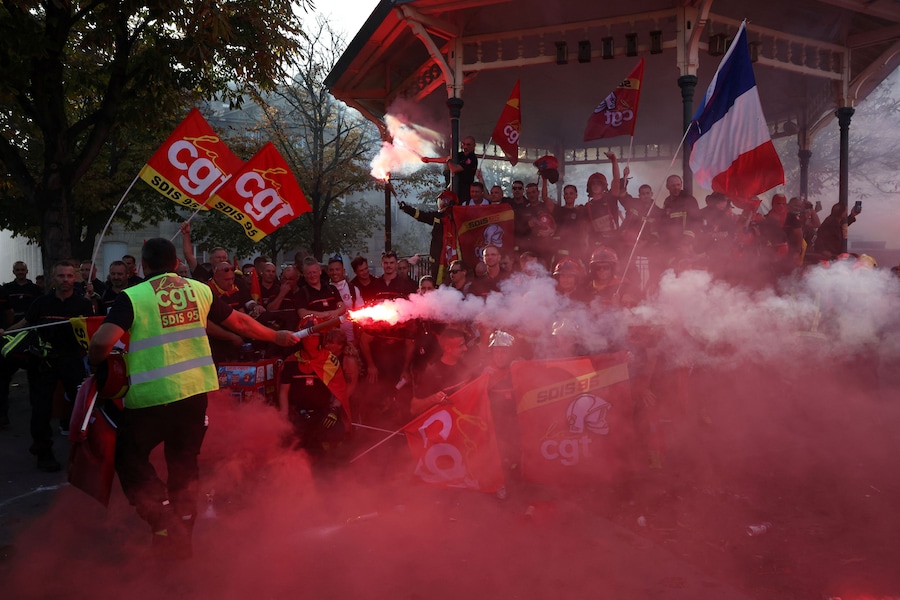 I vigili del fuoco francesi sventolano bandiere del sindacato CGT, la bandiera francese e razzi rossi durante una manifestazione per chiedere maggiori risorse e finanziamenti dopo un’estate segnata da incendi di vaste proporzioni, a Parigi, nell’ambito di una giornata di scioperi e proteste dei lavoratori del settore pubblico in Francia, il 29 settembre 2026. REUTERS/Tom Nicholson (REUTERS)