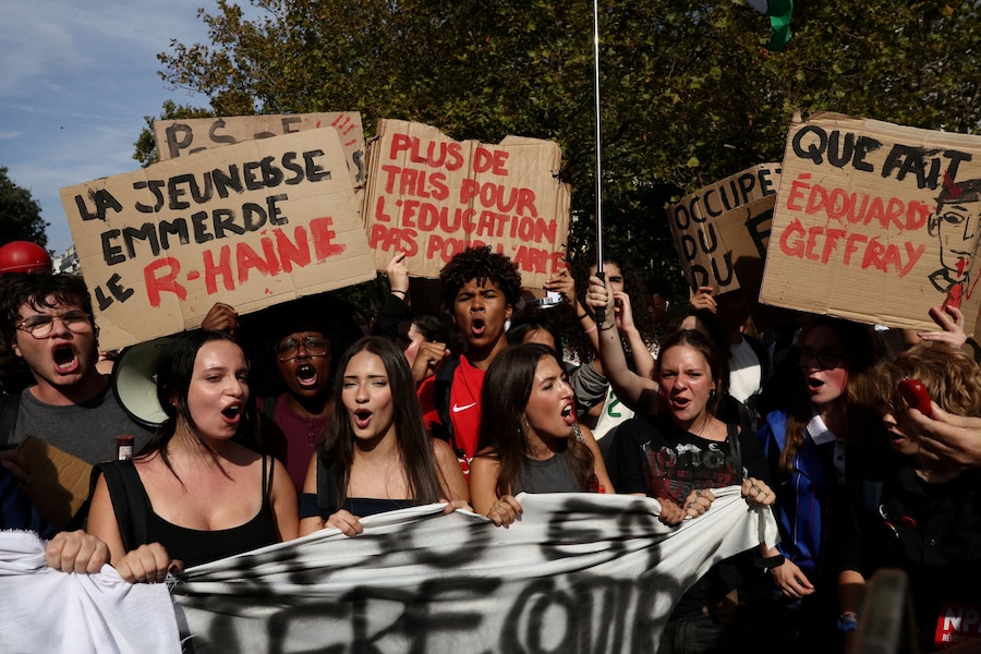 Studenti delle scuole superiori francesi espongono cartelli durante una manifestazione dei lavoratori del settore pubblico per chiedere migliori condizioni di lavoro e maggiori risorse, nell’ambito di una giornata di scioperi e proteste dei lavoratori del settore pubblico, tra cui i vigili del fuoco, a Parigi, in Francia, il 29 settembre 2026. Gli slogan recitano «I giovani dicono "Fanculo il Fronte Nazionale"» e «E allora, cosa sta facendo Edouard Geffray?». REUTERS/Tom Nicholson (REUTERS)