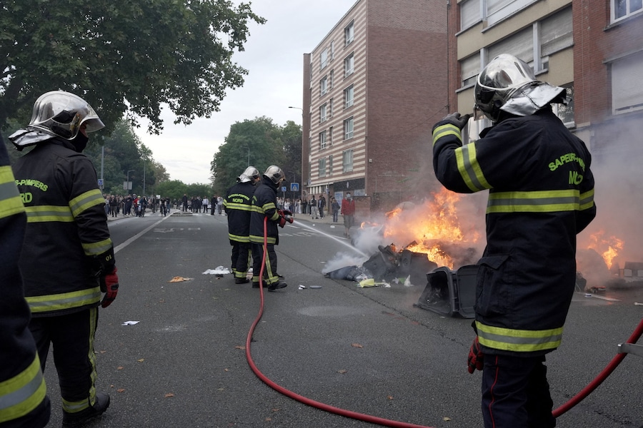 I vigili del fuoco francesi spengono dei cassonetti in fiamme durante una manifestazione di studenti delle scuole superiori nei pressi del Liceo Faidherbe a Lille, nell’ambito delle proteste nazionali per chiedere l’assunzione di insegnanti supplenti, maggiori risorse e migliori condizioni di apprendimento, in Francia, il 1° ottobre 2026. REUTERS/Noemie Olive (REUTERS)