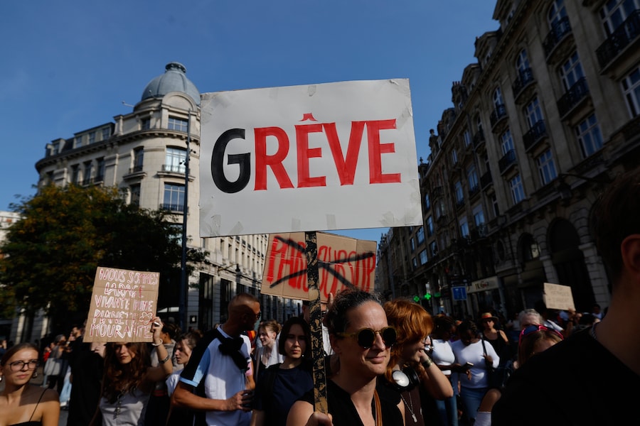 Una donna tiene in mano un cartello con la scritta "In sciopero" durante una manifestazione di protesta contro la pubblicazione da parte del governo del progetto di bilancio per il prossimo anno, a Lille, in Francia, martedì 29 settembre 2026. (AP Photo/Jean-Francois Badias) (APN)